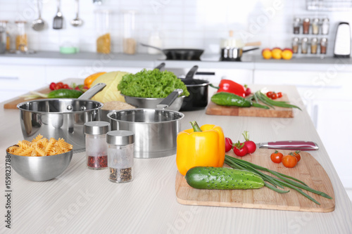 Fresh vegetables and utensils for cooking classes on wooden table