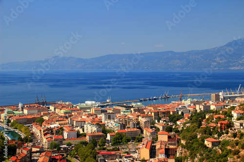 Sunny cityscape of Rijeka, the largest port of Croatia, with red rooftops of city center and the blue water of Kvarner Gulf, Adriatic Sea, in the background Ucka range, Istrian peninsula