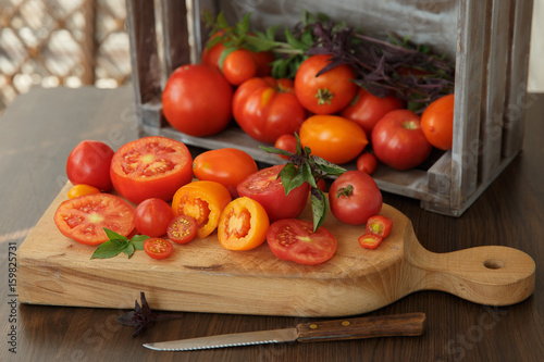 Tomatoes and basil on a wooden board in a rustic style