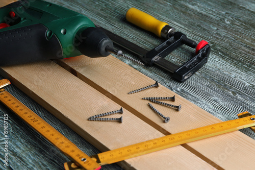 Set of tools and wooden boards on table in carpenter's workshop, closeup
