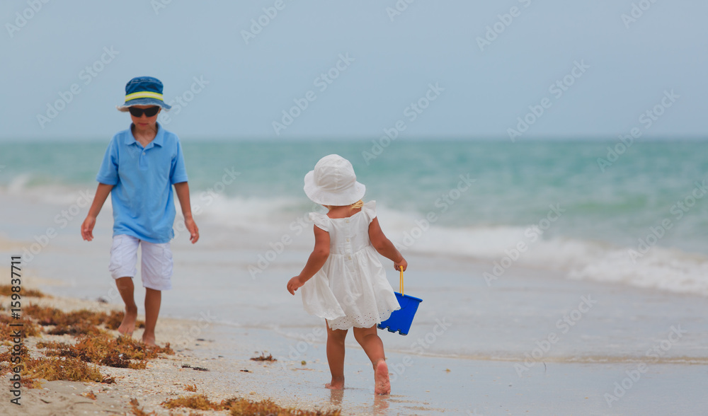 little boy and girl play on beach
