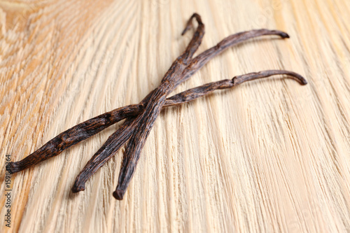 Dried vanilla sticks on wooden background, closeup