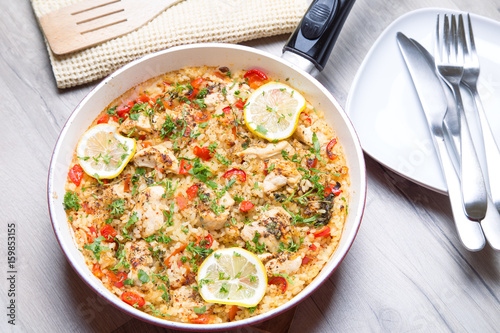 Paella with chicken, tomatoes and pepper . Traditional Spanish dish. Selective focus