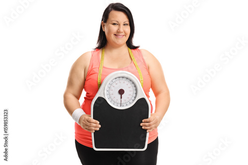 Overweight woman holding a weight scale © Ljupco Smokovski