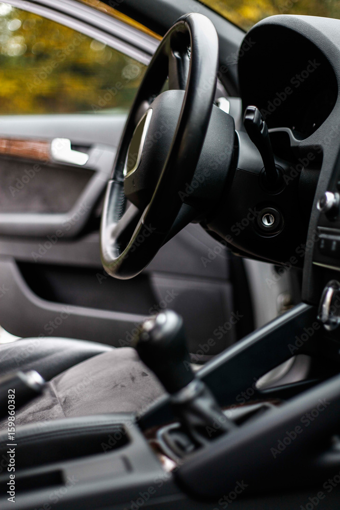 balck luxury car from inside. Close up of steering wheel, seat and circuit