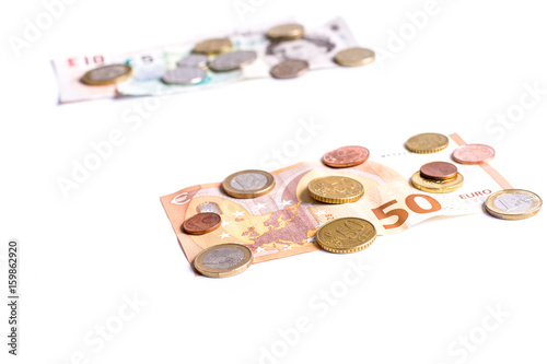 British Pound notes and coins and Euro notes and coins on white background