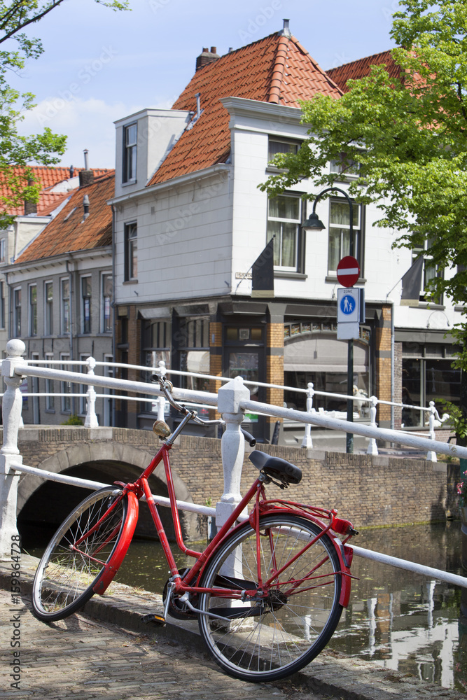 Red bicycle near a canal in Delft Red bicycle near a canal in Delft