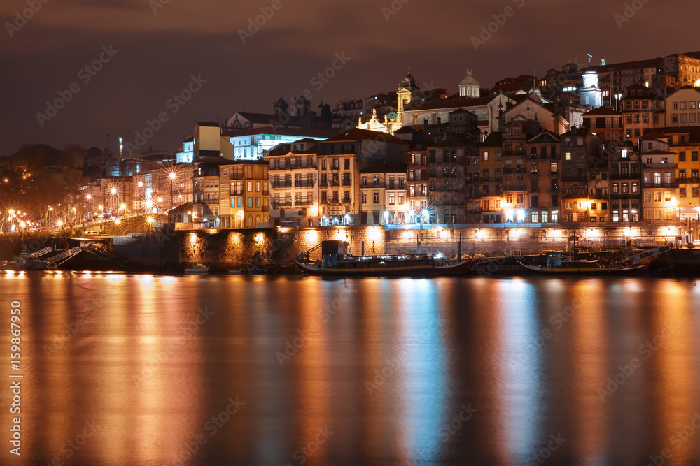 Ribeira and Old town of Porto with mirror reflections in the Douro River at night, Portugal, Portugal.
