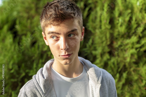 portrait of a smiling young man with green nature background