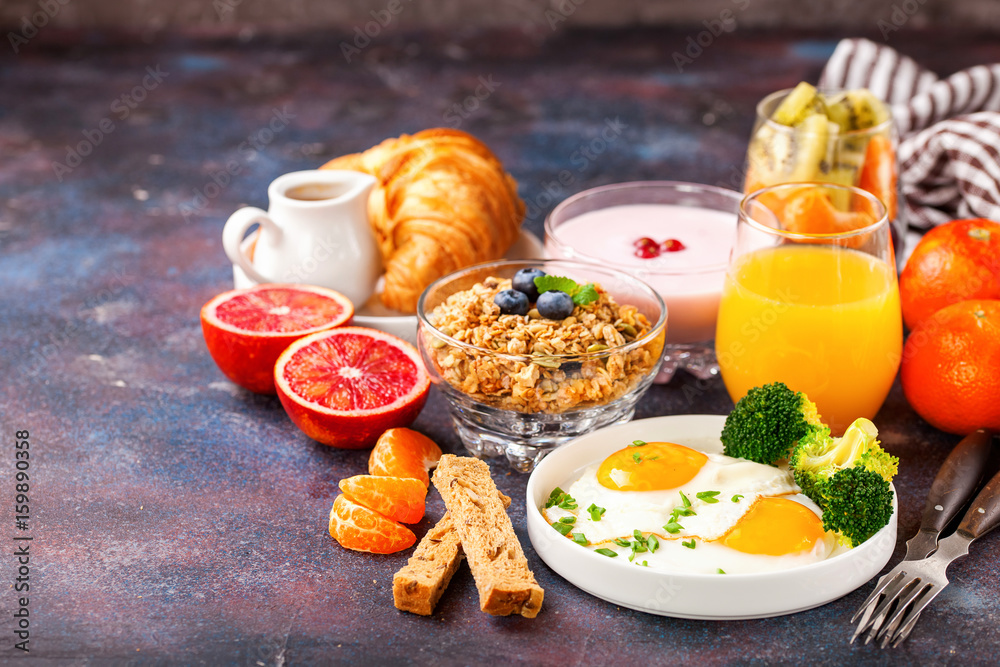 Breakfast - fried eggs with broccoli, muesli, croissant and juice on a table. Selective focus. Copy space