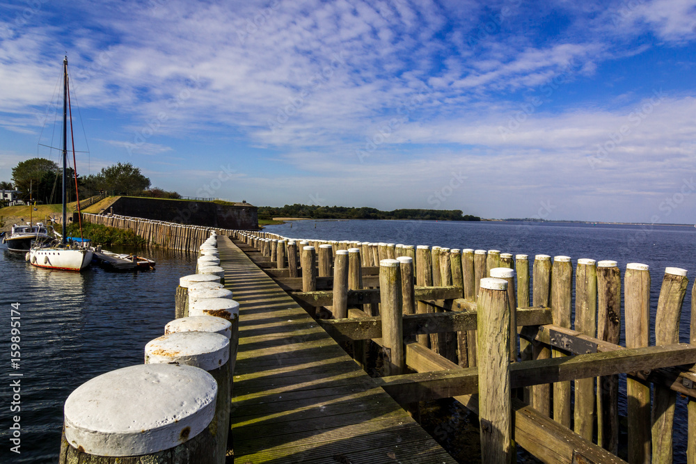 Obraz premium Holzsteg, Bootsanleger in Holland am Meer