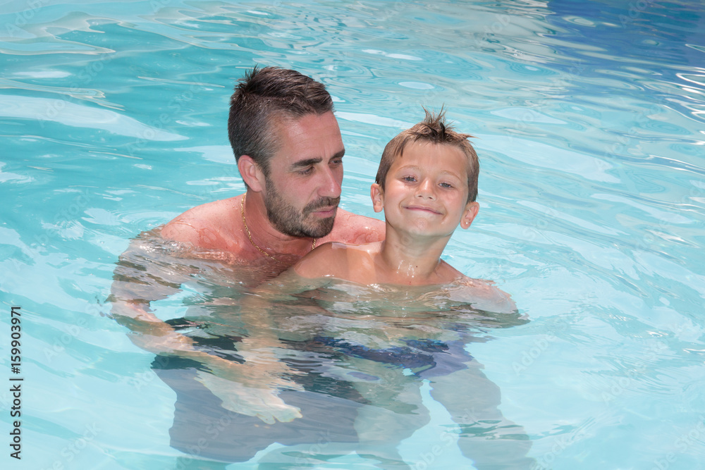 holidays in summer pool father and son complicity