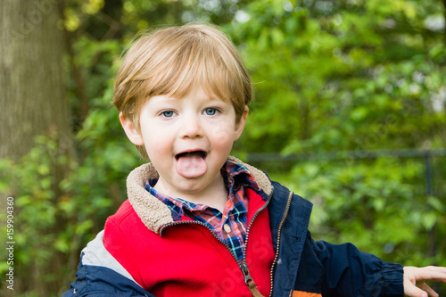 adorable toddler boy sticking tongue outside 