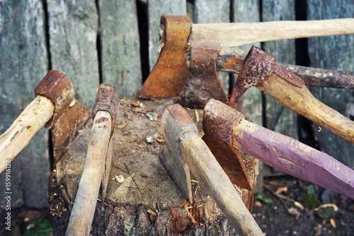 Old axes in a woodpile. Collection of old axes