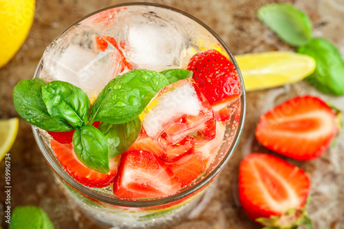 Summer a refreshing lemonade. Drink with lemon, strawberries, mint, Basil and ice. Detox. Mineral water. Selective focus
