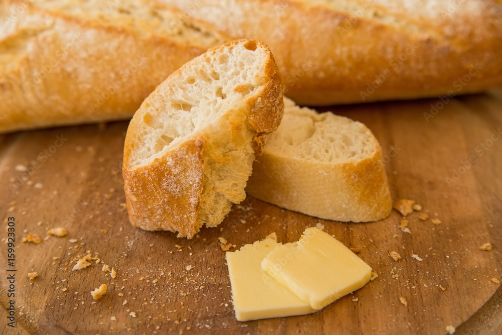 Baguete and slices of cheese on cutting board Baguete and slices of cheese on cutting board