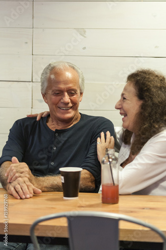 Smiling happy elderly couple have a coffe in a bar