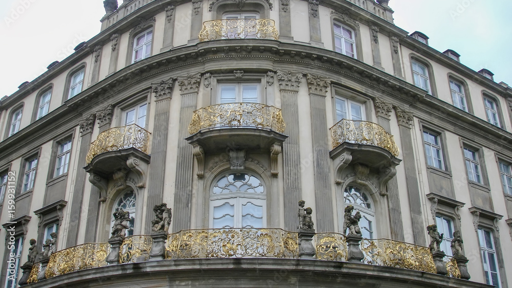 Corner of a building with gold coloured balconies