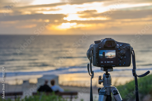 Kamera auf einem Stativ aufgebaut, um den Sonnenuntergang zu fotografieren photo