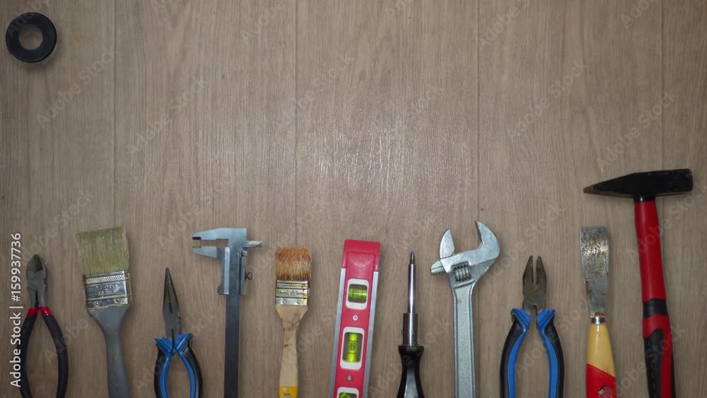 Different tools moving on wooden background. Hammer, screwdriver, pliers, brushes and over equipment fly from top of the screen to the bottom. With place for text. Animation based on real photos. 