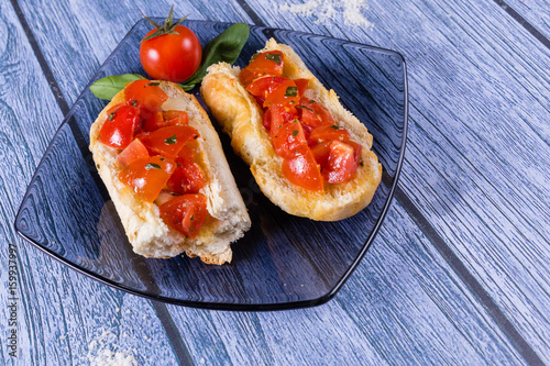 Italian bruschetta, a grilled crusty bread with tomatoes in pieces, basil and mozzarella cheese