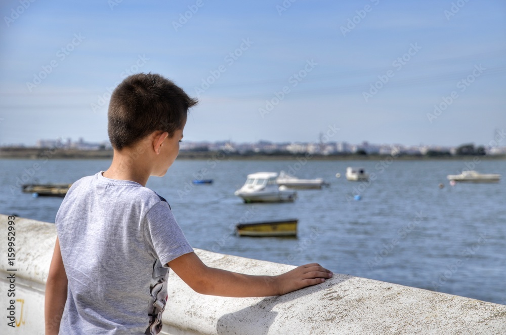 Niño mirando los barcos
