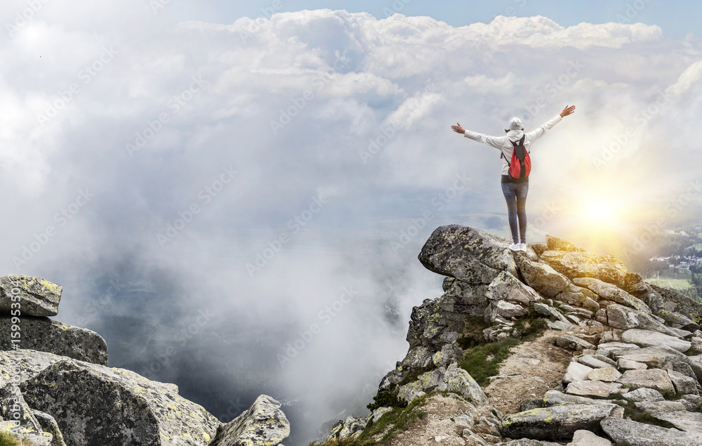 Obraz premium Tourist on the top of a mountain peak. Freedom - the concept.