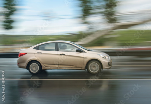 white car driven on rainy roads with blur background