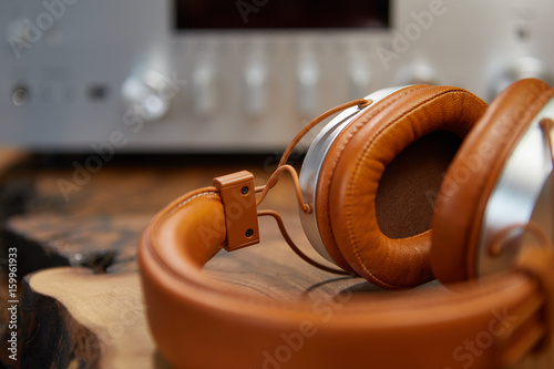 Vintage Headphones lie on a wooden table. Background amplifier hifi photo