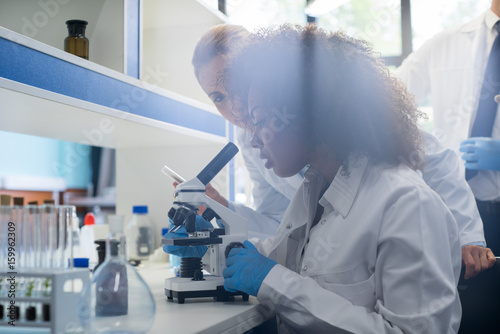 Male Scientist Working With Microscope, Team In Laboratory Doing Research, Man And Woman Making Scientific Experiments Doctors In Lab