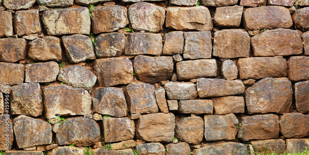 Wall assembled from a roughly processed natural stone