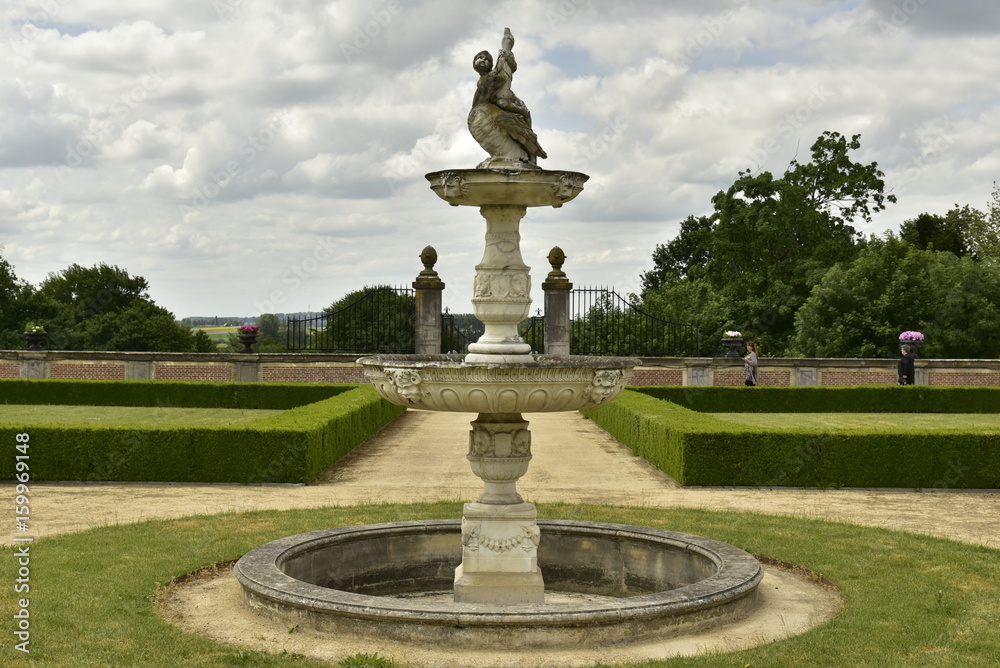 La fontaine rustique et circulaire au milieu du jardin à la française au domaine du château de Gaasbeek près de Bruxelles