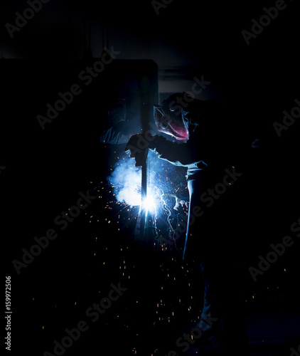 Fototapeta Naklejka Na Ścianę i Meble -  Anonymous labourer welding on iron