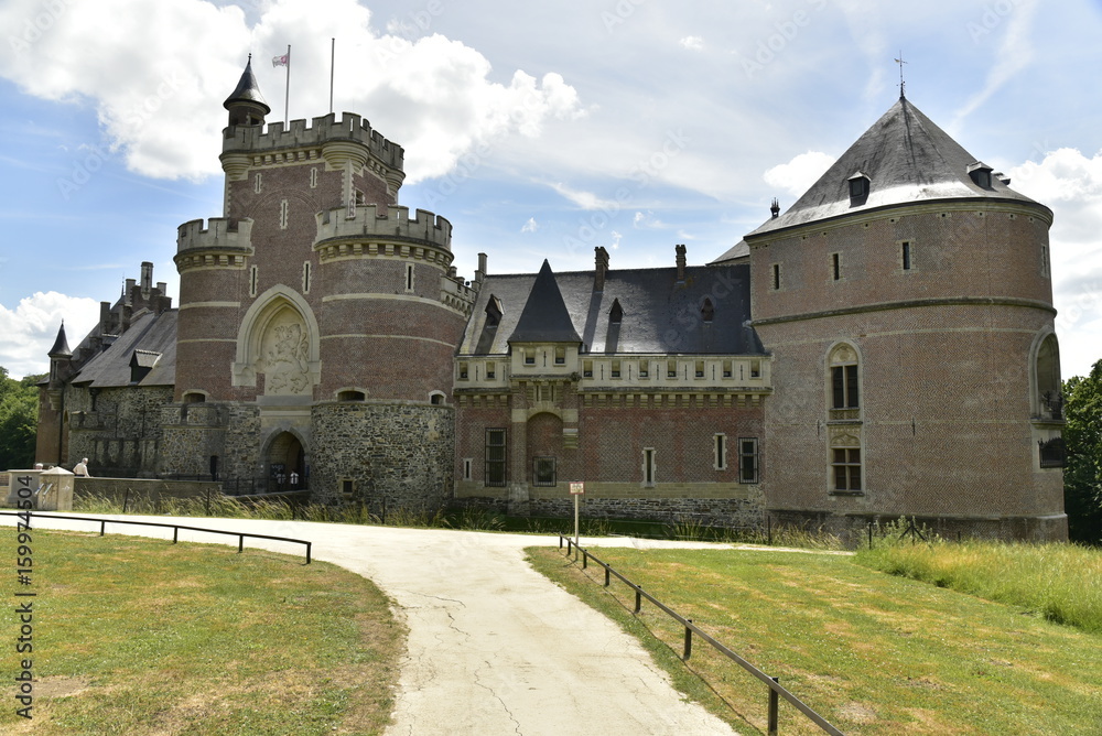 L'imposante muraille du château de Gaasbeek émergeant des chemins de son parc 