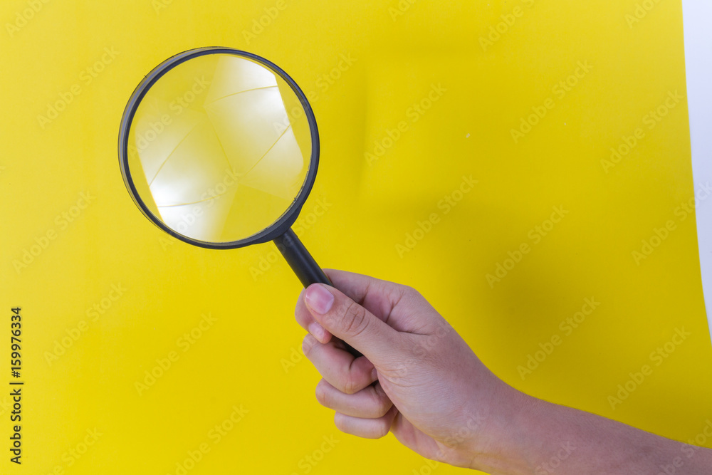 Hold Magnifying glass on yellow background Hold Magnifying glass on yellow background