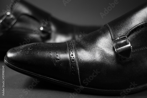 Close up of beautiful black leather men's shoes. Fashionable shoes isolated on black background. © Addoro