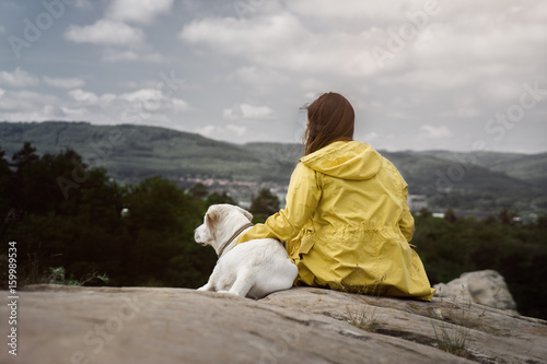 junge frau und schöner labrador retriever hund welpe in der natur auf einem berg beim spaziergang 