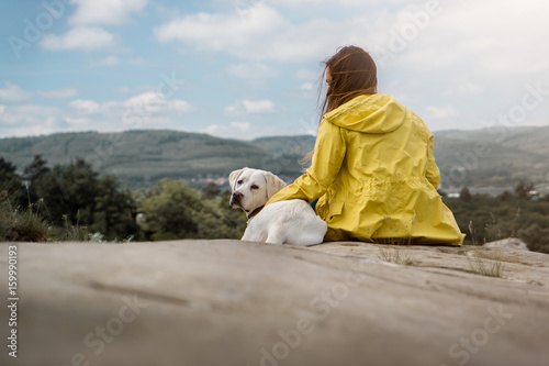 junge frau und schöner labrador retriever hund welpe in der natur auf einem berg beim spaziergang 