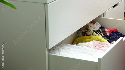 Storage of children's things in a white wooden dressing table