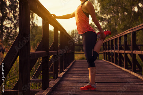 Sportliche Frau dehnt sich an einer Brücke nach dem Training