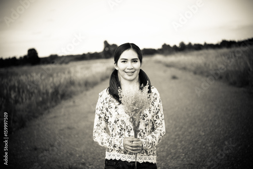 Portrait of beautiful woman smile she has flowers in hand,vintage style,dark tone,film tone