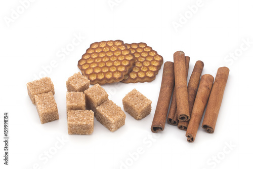 Biscuits, cane sugar, cinnamon sticks on white background