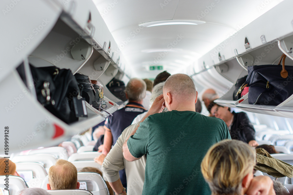 Fototapeta premium Ludzie czekający na opuszczenie samolotu