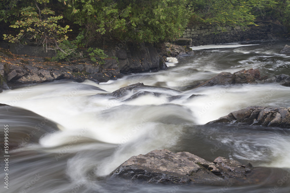 Fototapeta premium Waterfall and current movement in a river in the woods.