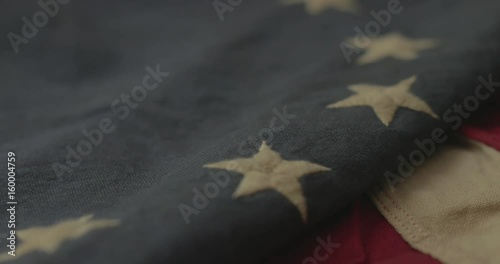 American flag detail with red and white stripes with field of blue and circle of 13 stars, the flag designed by Betsy Ross during the American Revolution. Shot in cinematic 4K.