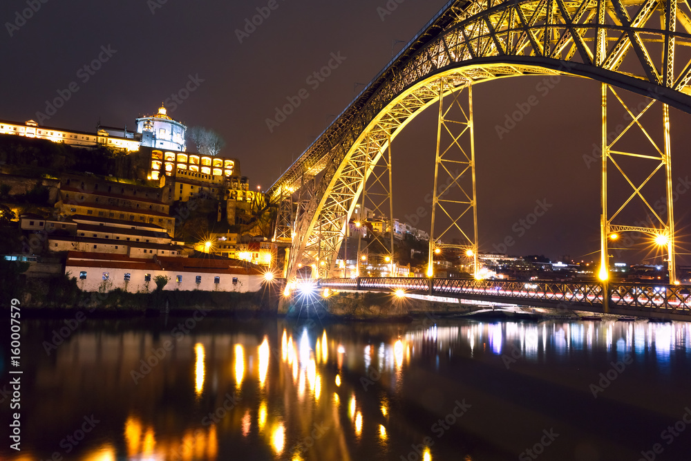 Dom Luis I or Luiz I iron arch bridge across Douro river with reflection and Monastery of Serra of Pilar in Porto at night, Portugal.