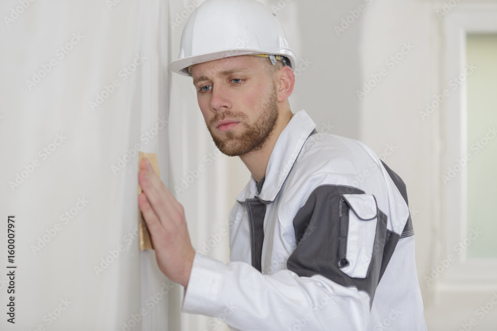 builder hand sanding interior wall for restoration builder hand sanding interior wall for restoration