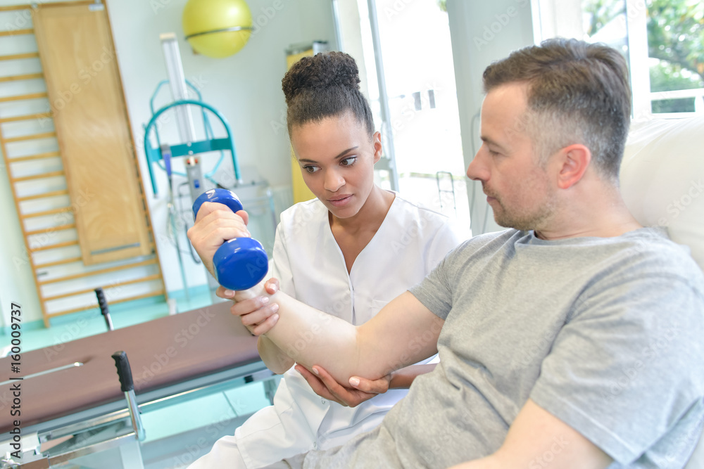Fototapeta premium middle age man in gym doing fitness exercises with dumbbells