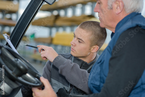 teacher helping student training to be car mechanics