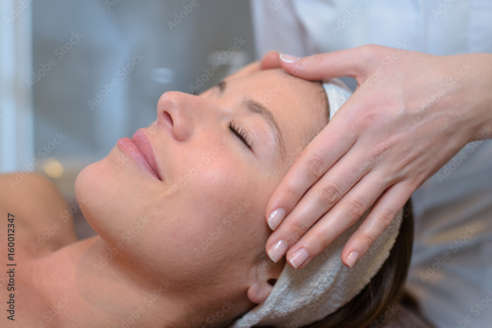 beautiful young woman receiving facial massage